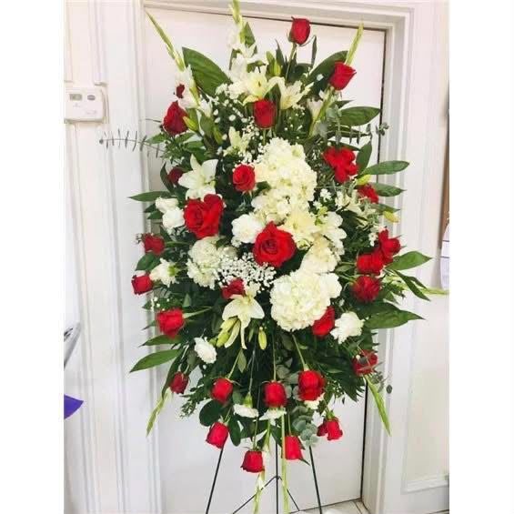 Standing funeral spray with red roses, white hydrangea and lilies delivered to a Rio Grande Valley funeral home